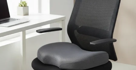 Ortopedický sedací vankúš s výrezom na kostrč položený na kancelárskej stoličke.